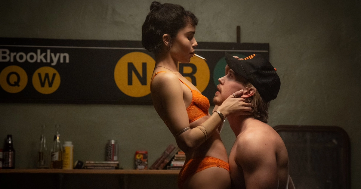 Austin Butler sem camisa encara Zoë Kravitz de lingerie laranja em cena sensual do filme Ladrões (2025), dirigido por Darren Aronofsky.