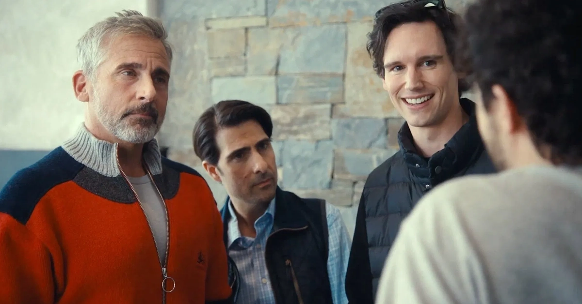 Cena do filme Mountainhead (2025), da HBO Max, com Steve Carell, Jason Schwartzman e Cory Michael Smith em destaque, em um ambiente interno com parede de pedra ao fundo