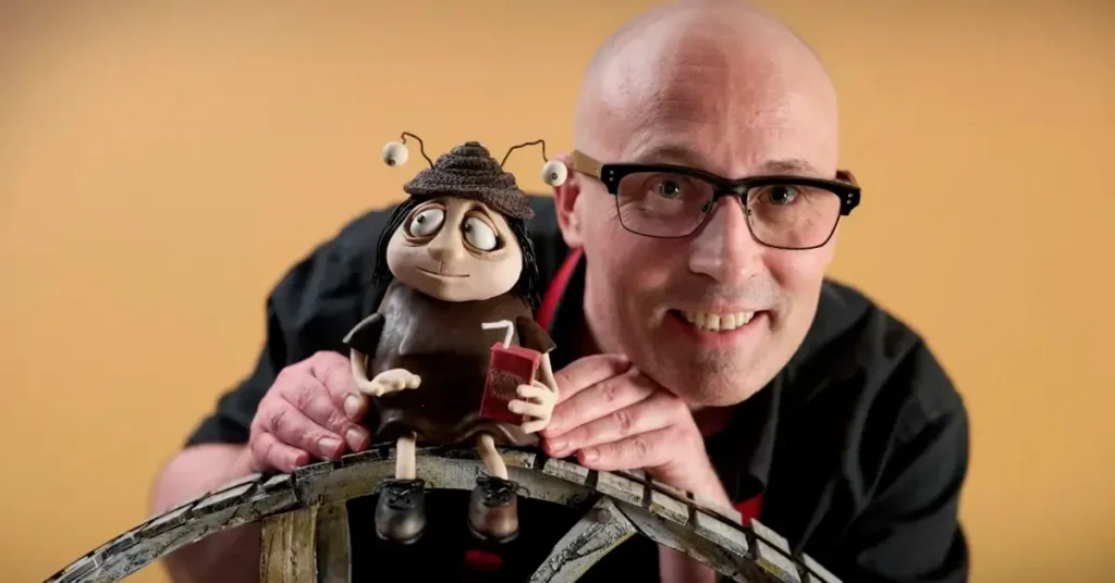 Adam Elliot posa ao lado de uma personagem em massinha do filme Memórias de um Caracol, sua nova animação em stop motion.