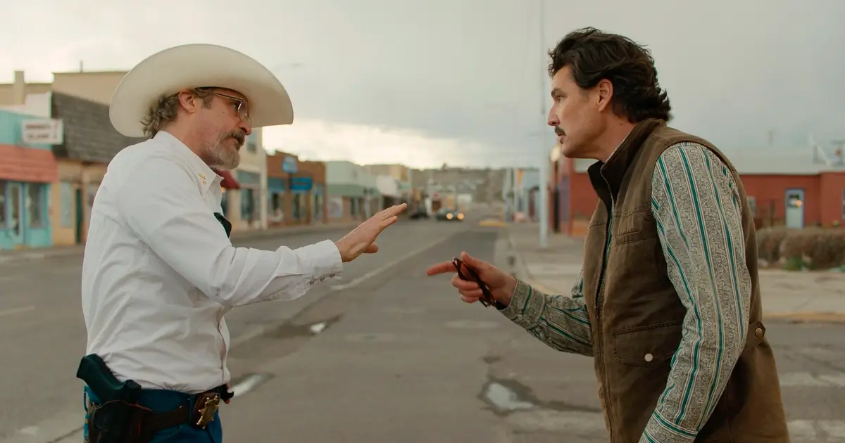 Cena do filme Eddington (2025) com Joaquin Phoenix e Pedro Pascal discutindo em uma rua deserta.