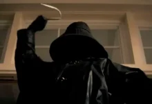 Assassino encapuzado empunha um gancho em cena do trailer do filme Eu Sei o que Vocês Fizeram no Verão Passado (2025), refilmagem do clássico do terror.