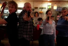 Cena intensa do filme Família à Prova de Balas com Kevin James, Christina Ricci e Luis Guzmán armados em uma lanchonete