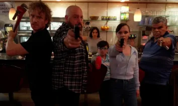 Cena intensa do filme Família à Prova de Balas com Kevin James, Christina Ricci e Luis Guzmán armados em uma lanchonete