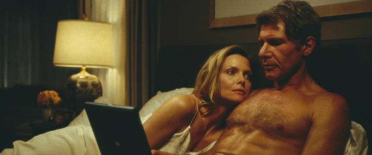 Cena do filme Revelação (2000) com Harrison Ford e Michelle Pfeiffer deitados na cama, em um momento íntimo do casal protagonista.