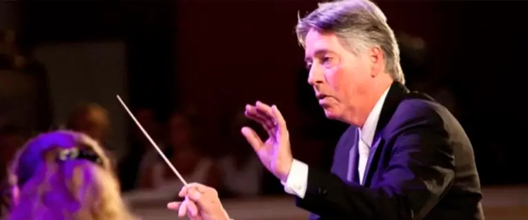 Alan Silvestri regendo uma orquestra durante apresentação; compositor da trilha sonora do filme Náufrago (2000).