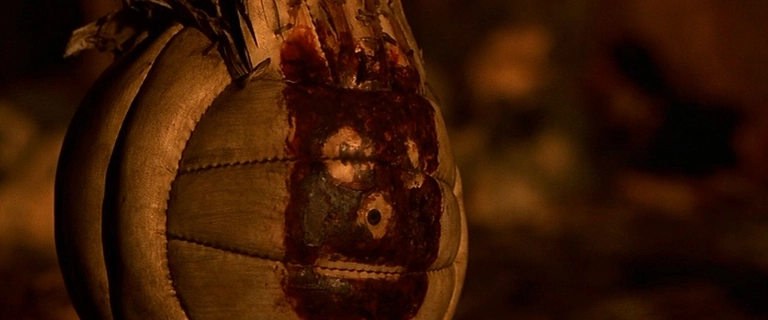 Cena do filme Náufrago (2000) mostrando a bola de vôlei Wilson com rosto feito de sangue, utilizada como companheira pelo personagem de Tom Hanks.