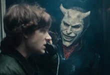 Cena do trailer de O Telefone Preto 2 mostra Finney (Mason Thames) em uma cabine telefônica, observado pelo sinistro vilão interpretado por Ethan Hawke, usando uma máscara demoníaca.