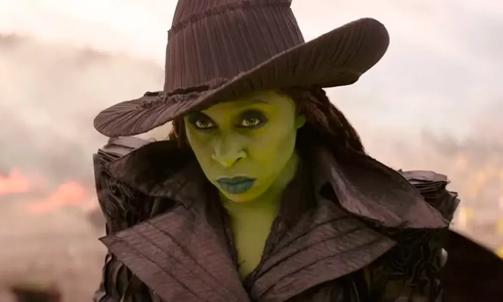 Elphaba com expressão séria e chapéu pontudo em cena de Wicked: Parte 2 (2025), interpretada por Cynthia Erivo.