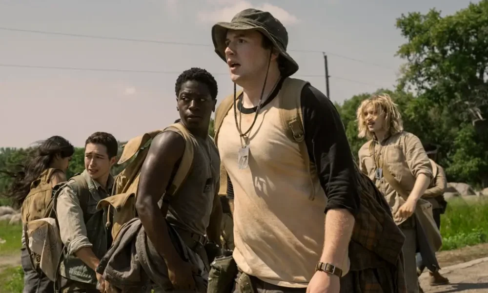 a longa marcha novo terror Cena do novo trailer de A Longa Marcha (2025), com jovens caminhando por uma estrada deserta em clima tenso.