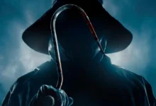 Figura sombria com capa e chapéu segurando um gancho ensanguentado, cena do filme Eu Sei o que Vocês Fizeram no Verão Passado (2025) – Estreia nos cinemas brasileiros em 17 de julho de 2025.