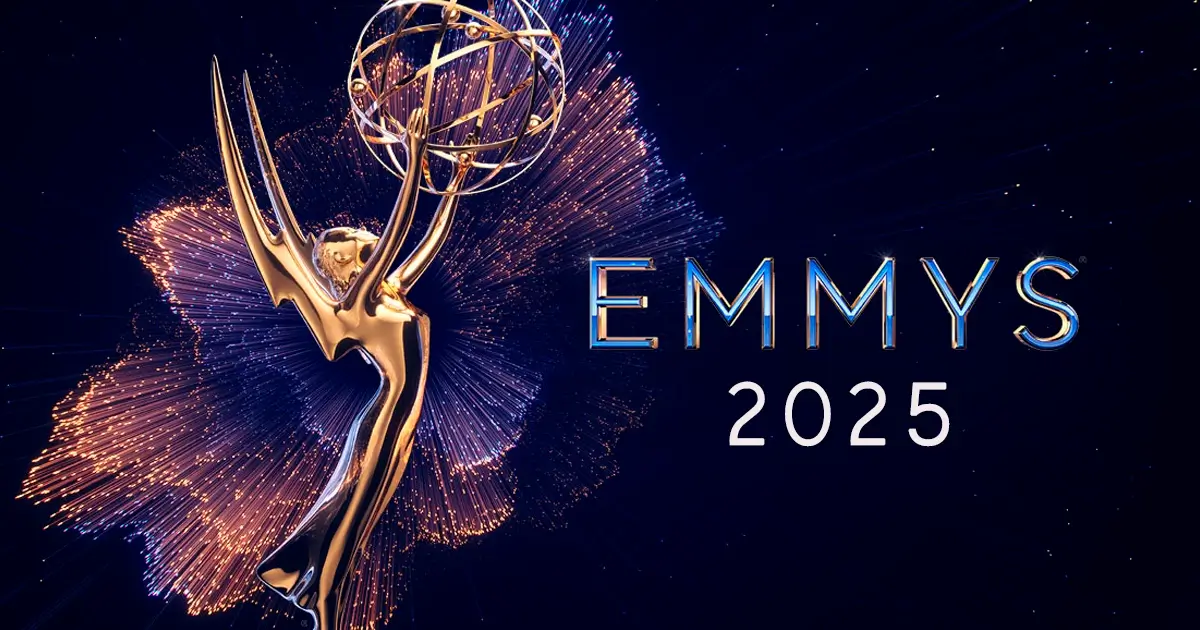Uma imagem da estatueta dourada do Emmy, com braços estendidos segurando um globo, cercada por brilhos dourados e azuis que se assemelham a fogos de artifício ou explosões de luz. À direita, as palavras "EMMYS 2025" estão escritas em letras maiúsculas, com "EMMYS" em azul metálico e "2025" em branco. O fundo é um céu noturno escuro.