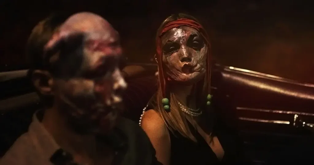 Pessoas com máscaras de pele ou rostos desfigurados em cena noturna do filme de terror Piscina Infinita (2023)