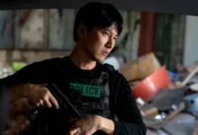 Kim Nam-gil armado e usando colete policial em cena da série sul-coreana Gatilho (Teurigeo), da Netflix