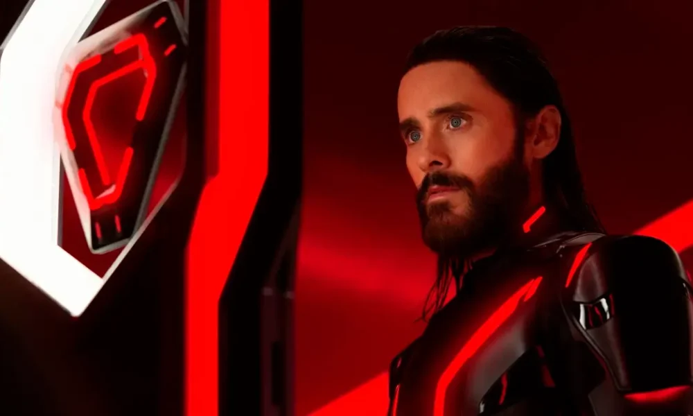 Cena do novo trailer de Tron: Ares (2025) com Jared Leto em traje futurista iluminado por luzes vermelhas e neon.