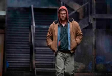 Glen Powell caminha em cena do filme O Concorrente (2025)