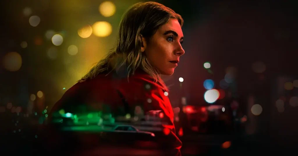 Vanessa Kirby em cena do filme A Noite Sempre Chega (2025) da Netflix, olhando pensativa com luzes coloridas de neon ao fundo