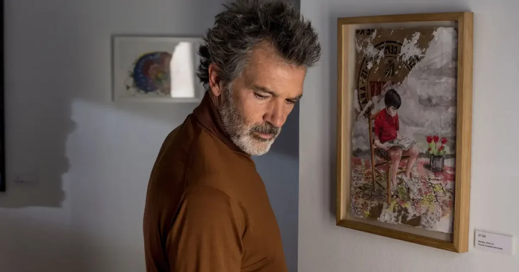 Antonio Banderas interpreta Salvador Mallo, olhando pensativo para um quadro, em cena do filme Dor e Glória (2019) dirigido por Pedro Almodóvar.