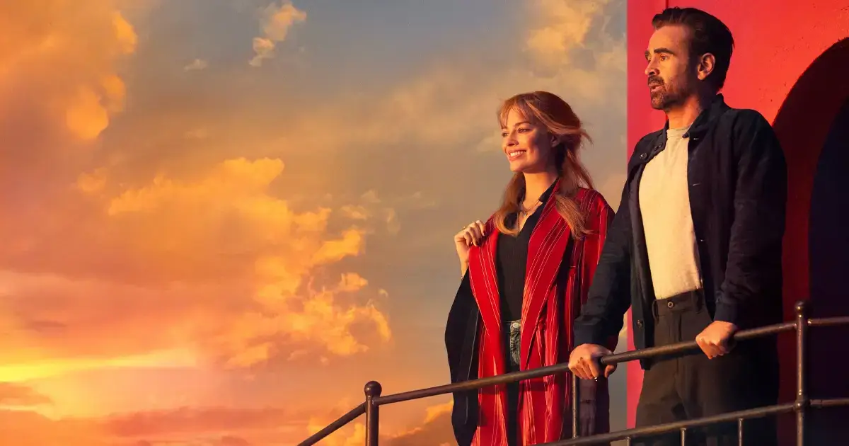 Cena do filme A Grande Viagem Da Sua Vida com Margot Robbie e Colin Farrell no pôr do sol, destaque do novo trailer de A Grande Viagem Da Sua Vida.