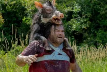 Jack Black em cena do trailer de Anaconda (2025), usando a cabeça de um javali como disfarce na selva.