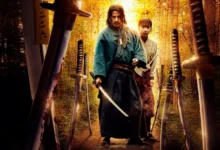 ate o ultimo samurai serie Jun'ichi Okada e Kaya Kiyohara em cena intensa da série japonesa Até o Último Samurai (2025), cercados por espadas em uma floresta iluminada pelo pôr do sol.