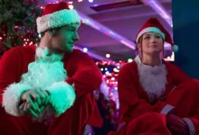 Olivia Holt e Connor Swindells vestidos de Papai Noel em cena do filme Feliz Assalto (Jingle Bell Heist, 2025), da Netflix.