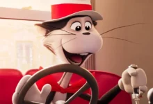 Cena do filme animado O Gatola da Cartola (2026), mostrando o carismático gato dirigindo um carro vermelho e sorrindo entusiasmado.