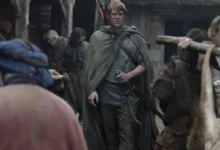 Peter Claffey como Ser Duncan, o Alto, caminhando por uma vila medieval em cena da série O Cavaleiro dos Sete Reinos da HBO Max.