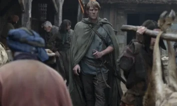 Peter Claffey como Ser Duncan, o Alto, caminhando por uma vila medieval em cena da série O Cavaleiro dos Sete Reinos da HBO Max.
