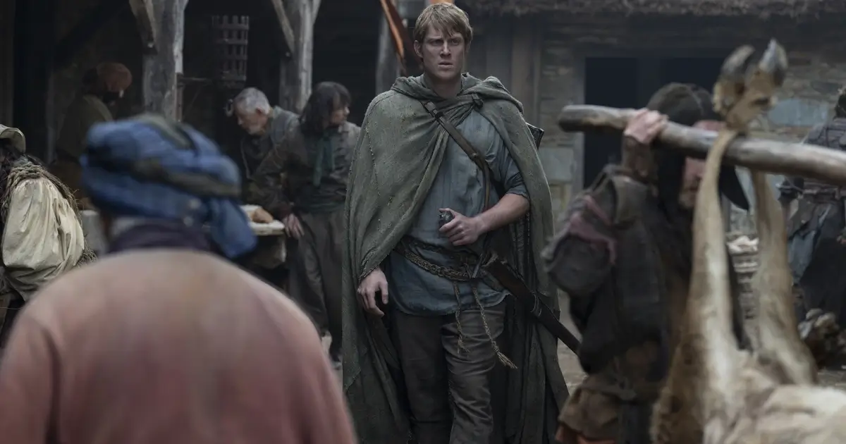 Peter Claffey como Ser Duncan, o Alto, caminhando por uma vila medieval em cena da série O Cavaleiro dos Sete Reinos da HBO Max.