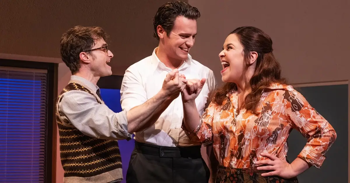 Daniel Radcliffe, Jonathan Groff e Lindsay Mendez em cena do musical Merrily We Roll Along, dirigido por Maria Friedman.