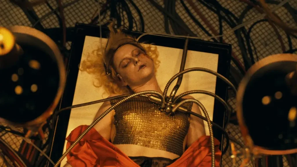 Jessie Buckley deitada cercada por cabos e equipamentos em cena de A Noiva (The Bride), terror gótico de Maggie Gyllenhaal nas estreias de 2026