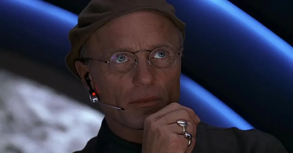ed harris o show de truman Ed Harris como Christof em O Show de Truman 1998 usando headset e óculos redondos na sala de controle