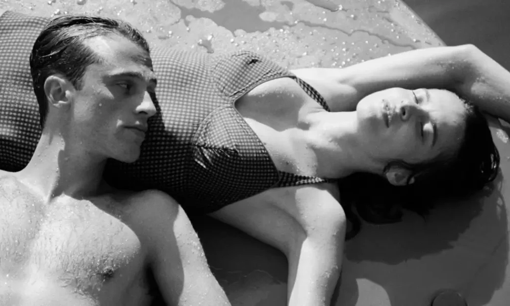 filme o estrangeiro 2025 Rebecca Marder e Benjamin Voisin deitados juntos em cena do filme O Estrangeiro (2025), dirigido por François Ozon, durante o Festival de Cinema Francês do Brasil