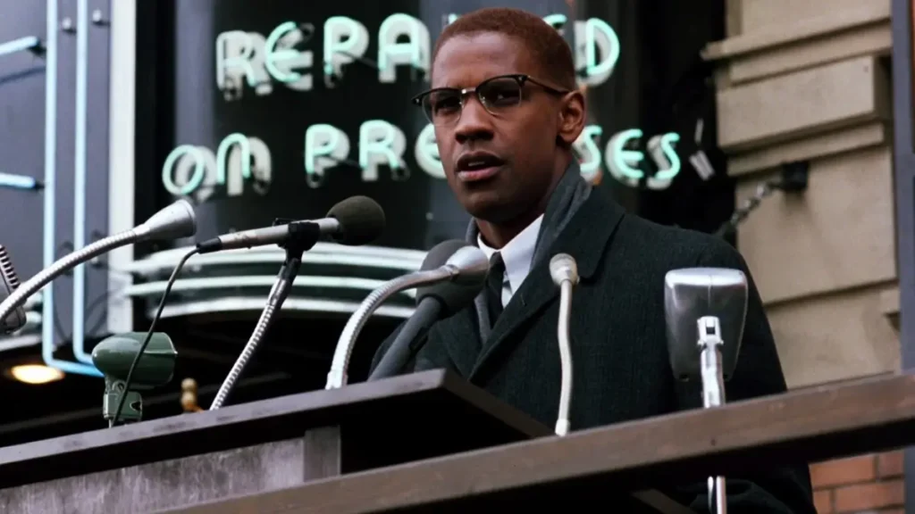 malcolm x 1992 filme Denzel Washington como Malcolm X discursando em púlpito cercado de microfones