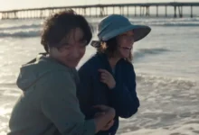 Lucy Liu e Lawrence Shou sorrindo na praia em uma cena do filme Rosemead (2025), drama baseado em uma história real dirigido por Eric Lin.