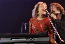 Kate Hudson e Hugh Jackman cantando juntos em cena de Song Sung Blue – Um Sonho a Dois (2025), musical dirigido por Craig Brewer.