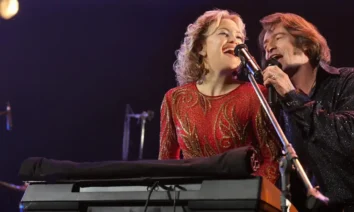 Kate Hudson e Hugh Jackman cantando juntos em cena de Song Sung Blue – Um Sonho a Dois (2025), musical dirigido por Craig Brewer.