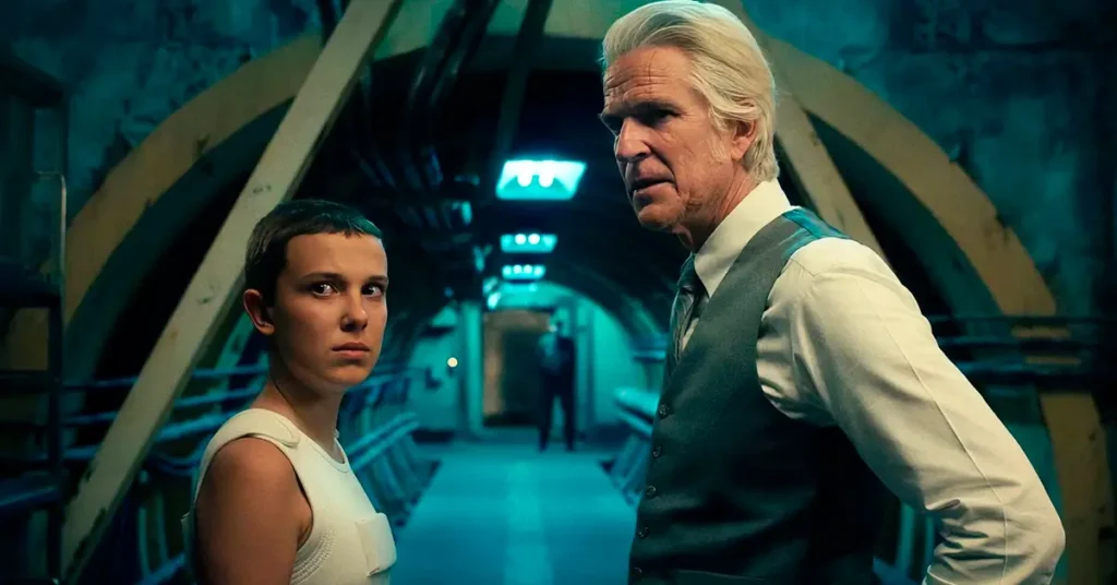 stranger things 4 episodio 8 papai Eleven e Dr. Brenner em corredor subterrâneo em Stranger Things 4, durante os eventos do episódio Papai.