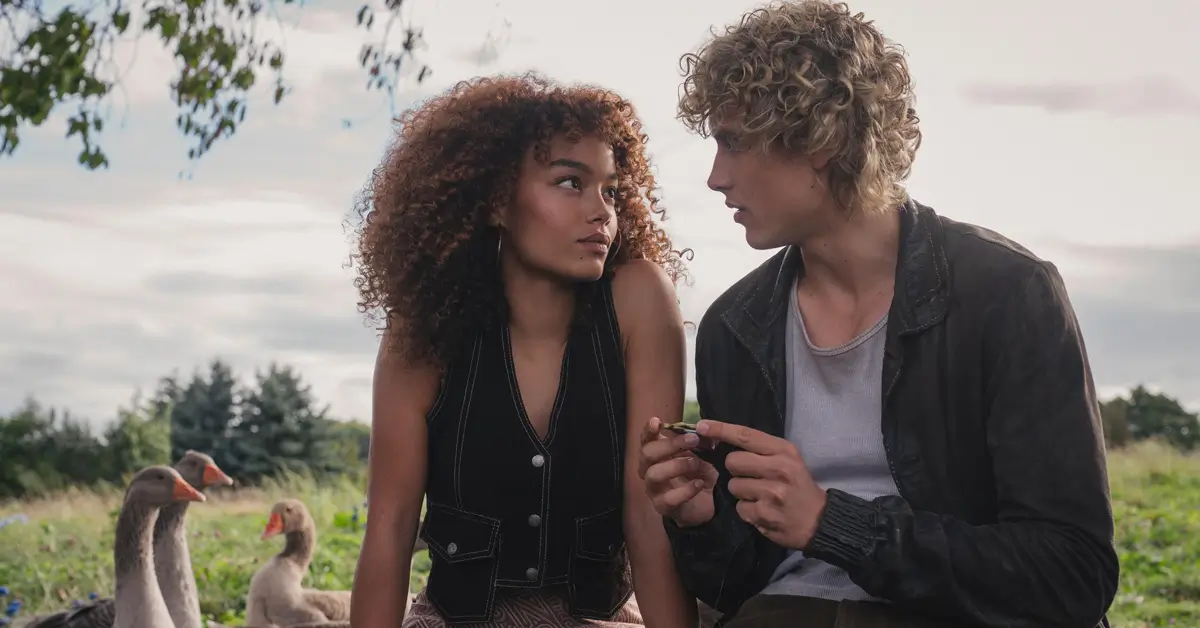 teaser de jogos vorazes amanhecer na colheita 2026 Joseph Zada e Whitney Peak em cena do Teaser de Jogos Vorazes - Amanhecer na Colheita, conversando em ambiente rural com gansos ao fundo