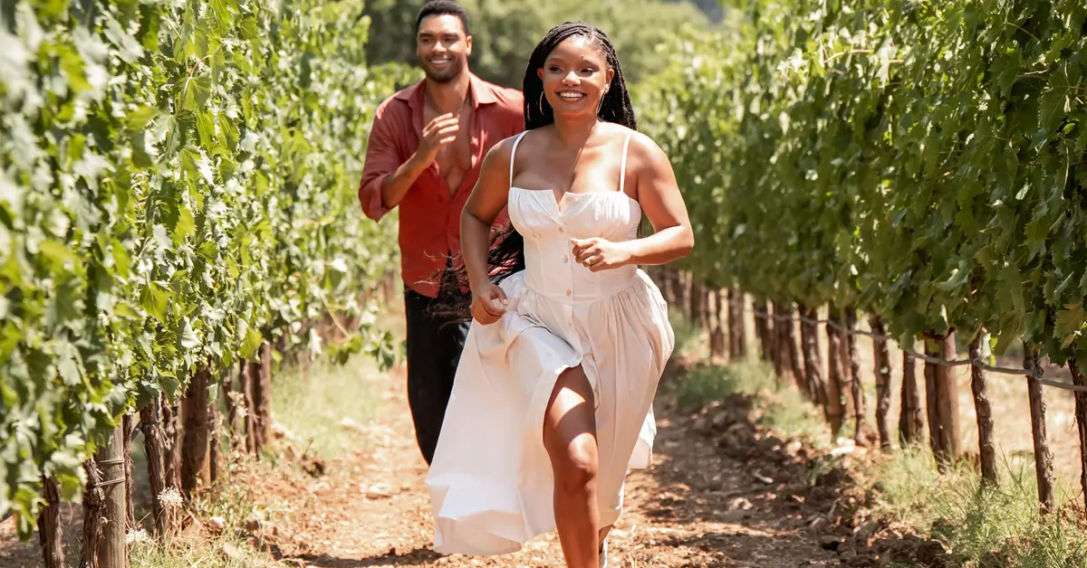 Cena romântica de Halle Bailey e Regé-Jean Page correndo em um vinhedo na Toscana no filme Tu e Eu na Toscana (2026).