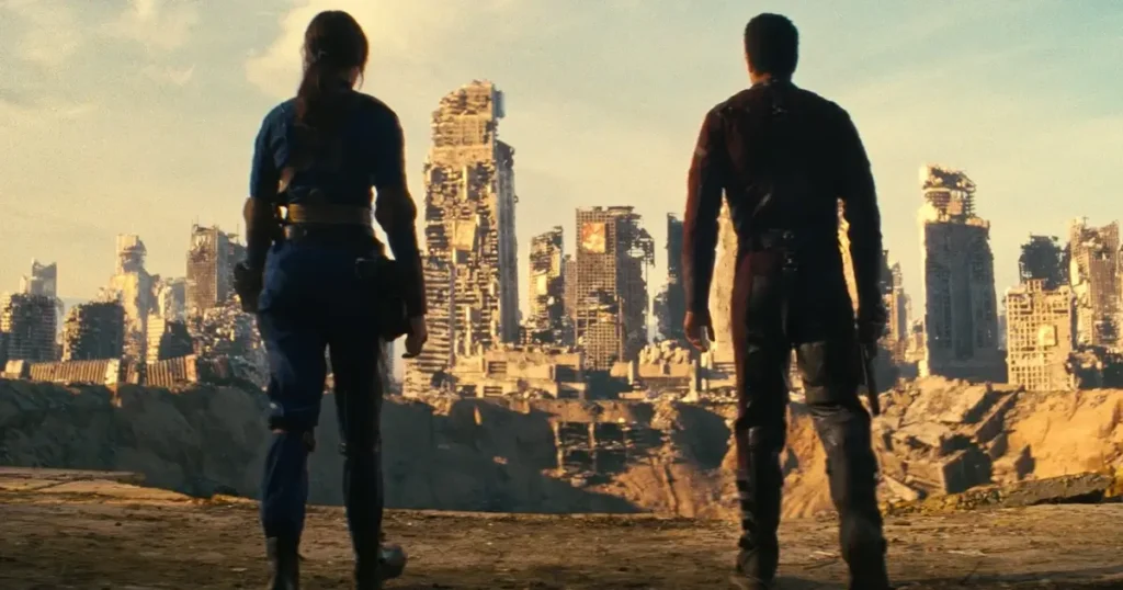 Lucy e Maximus observam as ruínas destruídas de Shady Sands no episódio “O Passado”, da série Fallout (2024).