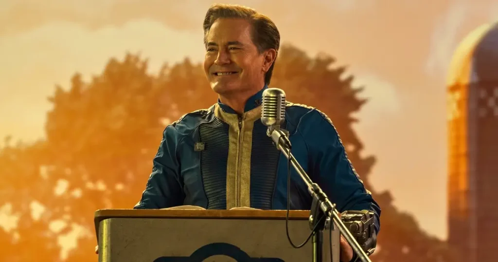 Kyle MacLachlan como o Overseer Hank MacLean discursando no Vault 33 durante o episódio piloto da série Fallout (2024).