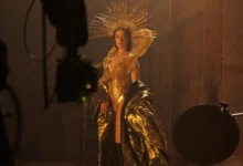 filme mother mary 2026 Anne Hathaway caracterizada em uma luxuosa roupa dourada no set de “Mother Mary”, drama da A24 dirigido por David Lowery.