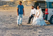 filmes 04 de dezembro de 2025 Cena do filme iraniano “Foi Apenas um Acidente”, destaque entre as estreias de 04 de dezembro de 2025, mostrando um casal vestido para casamento e um homem ao lado de uma van no deserto.