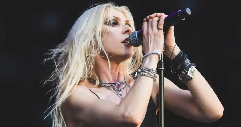 Taylor Momsen cantando no palco como vocalista da banda The Pretty Reckless.