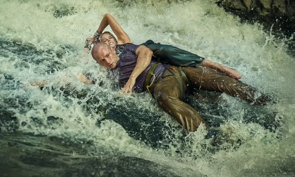 Charlize Theron e Taron Egerton em cena de ação no filme O Jogo do Predador (Apex), produção da Netflix com estreia em 24 de abril de 2026
