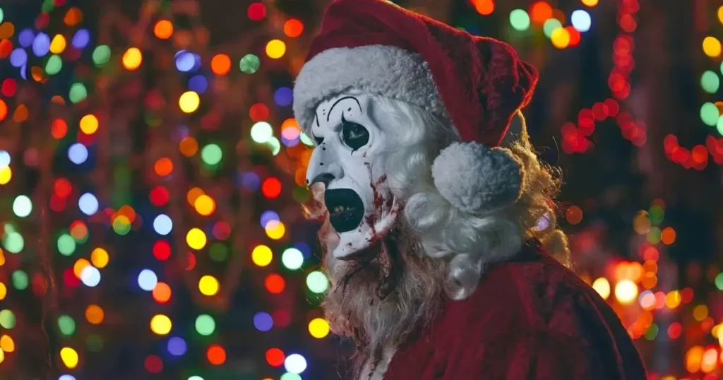 terrifier 3 David Howard Thornton como Art the Clown vestido de Papai Noel em Terrifier 3, filme natalino violento, restrito para menores, com estética sangrenta e atmosfera perturbadora.