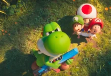 Yoshi segurando uma arma laser enquanto Baby Mario, Baby Luigi e Toad observam o céu em cena do novo trailer de Super Mario Galaxy: O Filme.