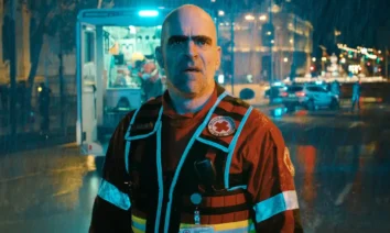 Luis Tosar usando uniforme de equipe de emergência sob chuva, em cena noturna da série espanhola da Netflix Salvador.
