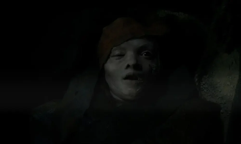 Cena sombria do primeiro teaser de Maldição da Múmia (Lee Cronin’s The Mummy), revelando figura mumificada em ambiente escuro no novo filme de terror dirigido por Lee Cronin.